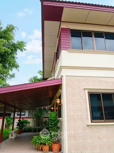 Charming two-story house with covered patio and lush greenery, perfect for family living.