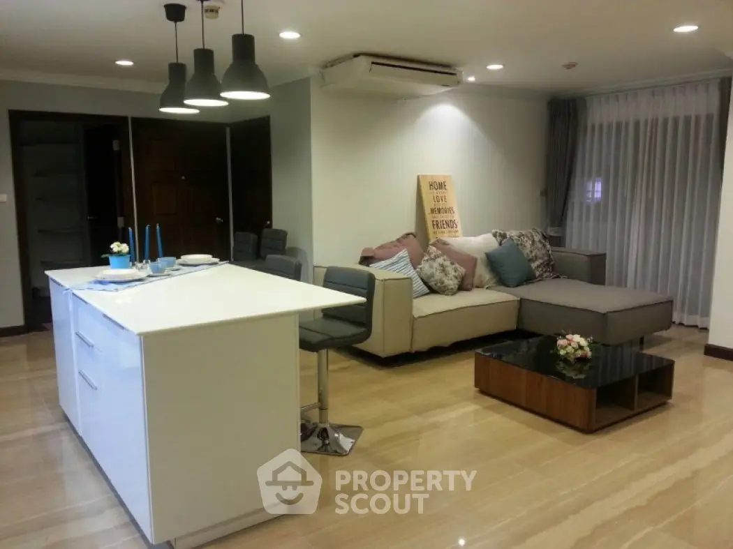 Modern open-layout living room with stylish kitchen island and cozy seating area.
