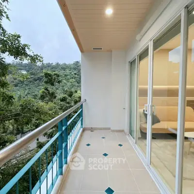 Spacious balcony with scenic forest view and sliding glass doors leading to modern interior.
