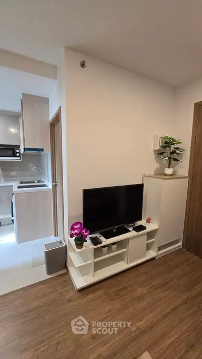 Modern living room with sleek TV stand and open kitchen layout