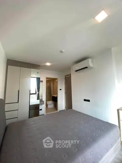 Modern bedroom with ensuite bathroom and air conditioning in a stylish apartment.