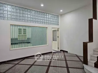 Spacious interior with modern design and unique glass block wall feature.