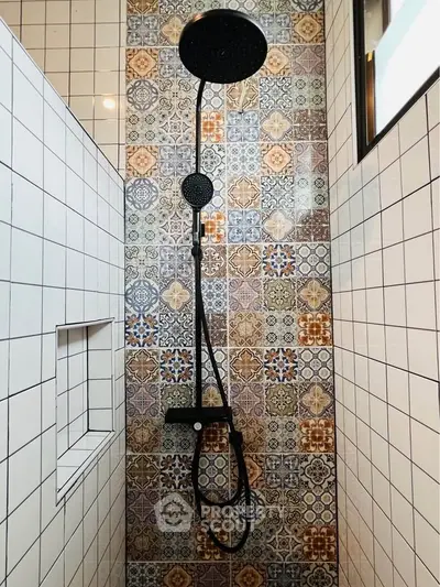 Stylish bathroom shower with colorful patterned tiles and modern fixtures.