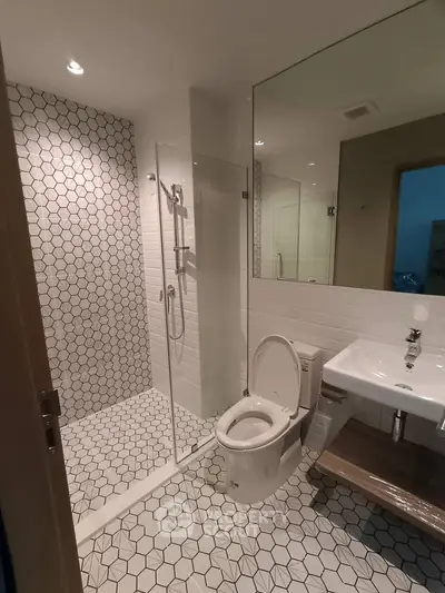 Modern bathroom with glass shower and stylish hexagonal tiles