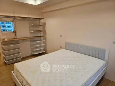 Spacious bedroom with modern built-in storage and cozy bed