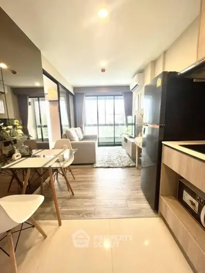 Modern open-plan living room with kitchen, stylish decor, and natural light.