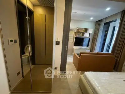Modern apartment interior with open living room and bedroom, featuring sleek design and large windows.