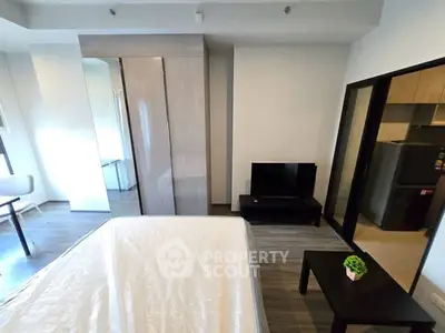 Modern bedroom with sleek furniture and open kitchen view