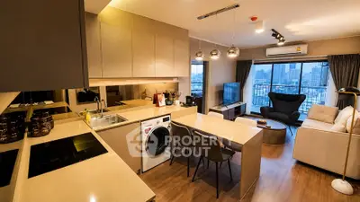 Modern open-layout kitchen and living room with city view, featuring sleek design and cozy seating area.