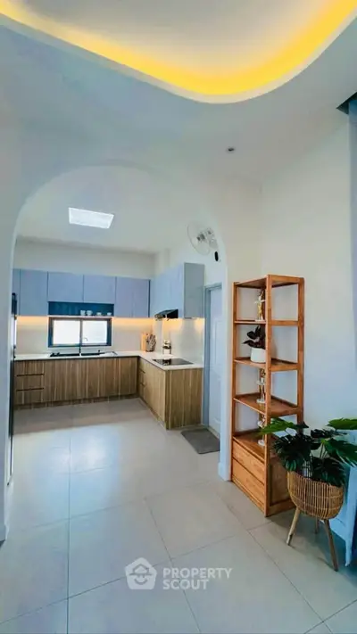 Modern kitchen with sleek cabinetry and open layout, featuring stylish lighting and contemporary design.