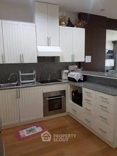 Modern kitchen with sleek white cabinetry and built-in oven