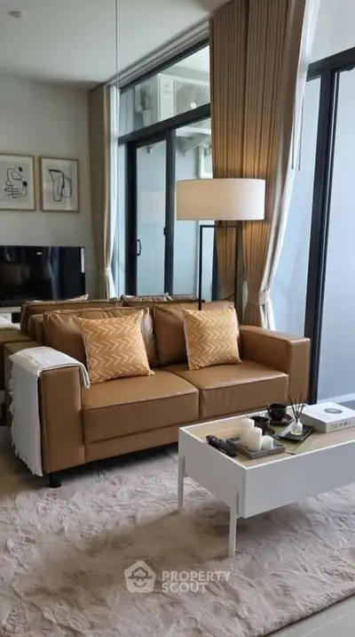 Stylish living room with modern decor, cozy sofa, and large windows for natural light.