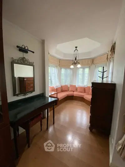 Charming living room with bay windows and elegant furnishings, perfect for cozy gatherings.