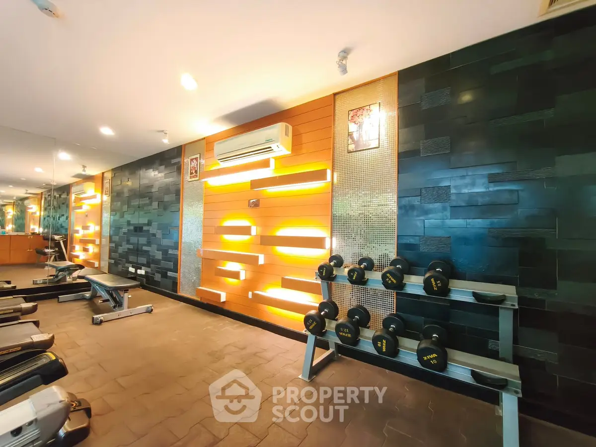 Modern gym with stylish lighting and fitness equipment in upscale residential building.