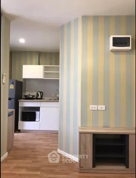 Modern kitchen with striped wallpaper and wooden flooring, featuring appliances and open shelving.