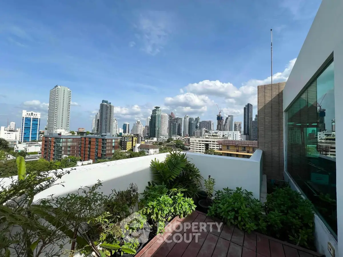 Stunning cityscape view from a modern rooftop garden terrace with lush greenery.