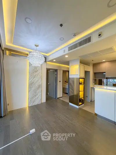 Luxurious modern living room with elegant chandelier and open kitchen layout