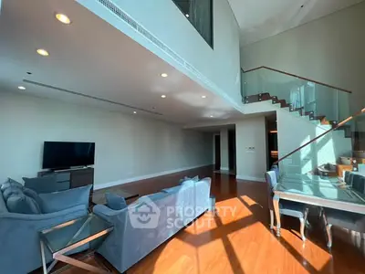 Spacious modern living room with high ceilings and elegant staircase