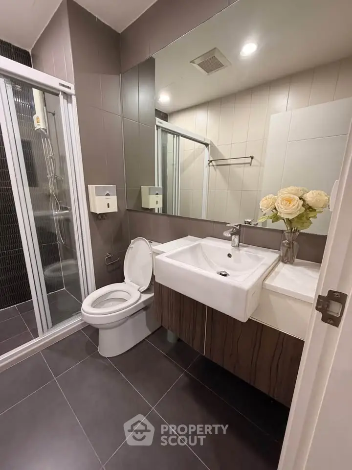 Modern bathroom with sleek design, featuring a glass shower and elegant sink.