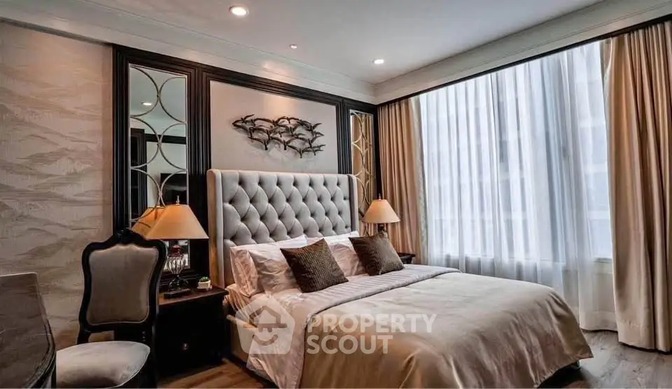 Luxurious bedroom with elegant decor and large window, featuring plush bedding and stylish furnishings.