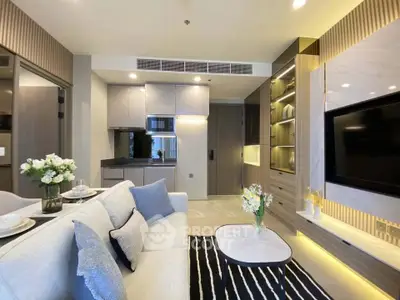 Modern living room with open kitchen, stylish decor, and cozy ambiance in a contemporary apartment.