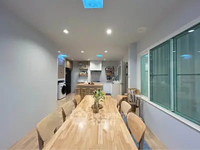 Spacious dining area with modern kitchen and skylights, perfect for family gatherings.