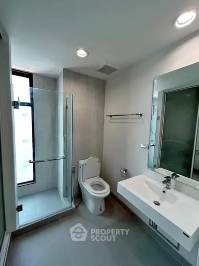 Modern bathroom with glass shower and sleek fixtures in a contemporary apartment.