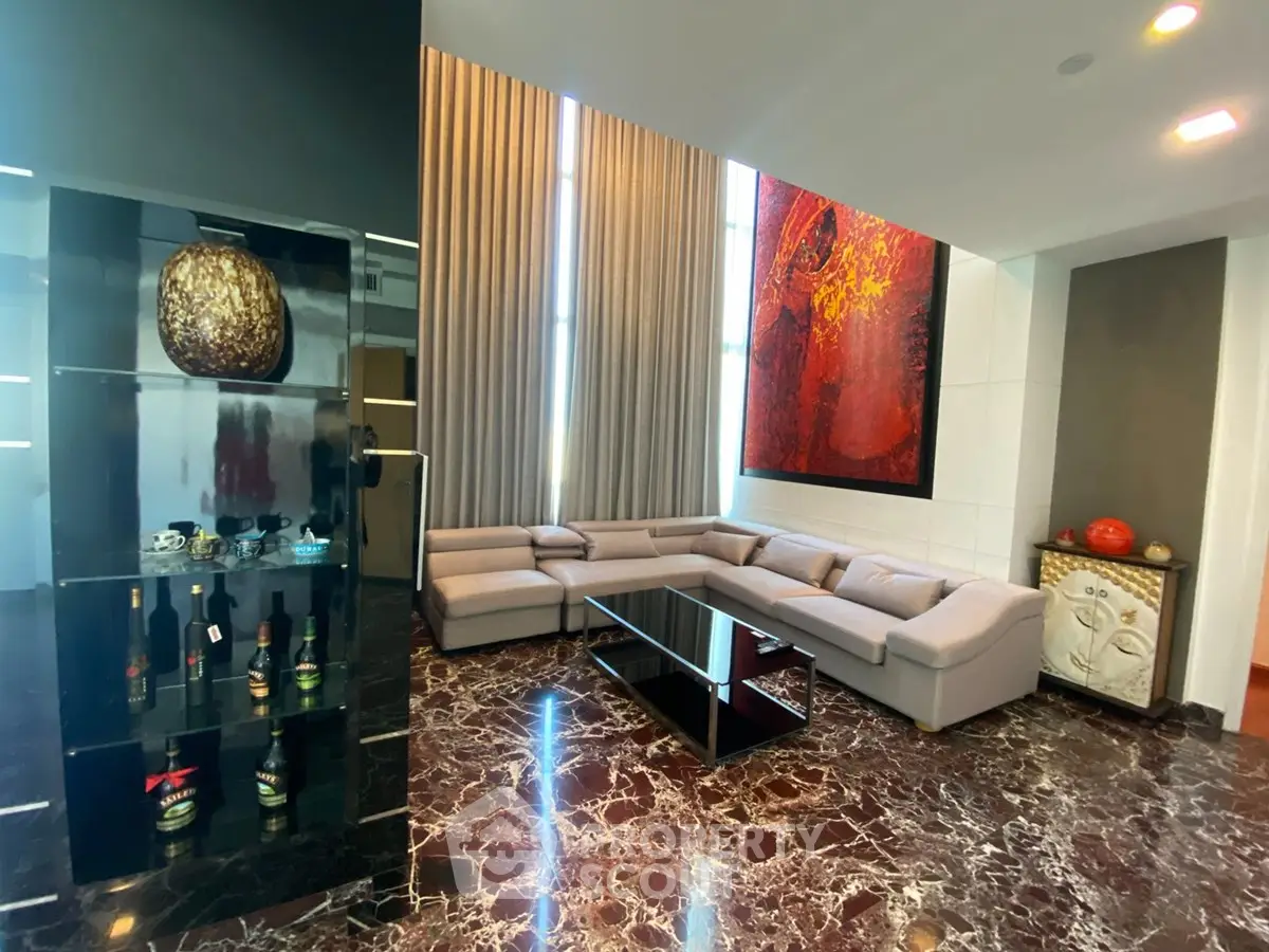 Luxurious living room with marble flooring, modern sectional sofa, and elegant decor in a high-end apartment.