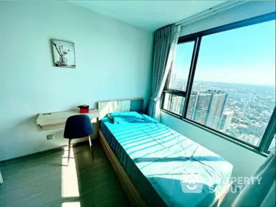 Bright bedroom with city view, featuring a single bed and study desk, perfect for urban living.