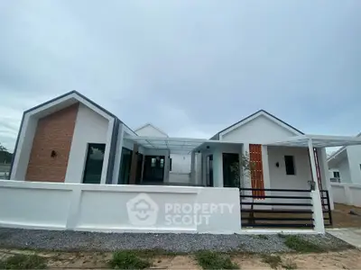 Modern minimalist single-story house with unique architectural design and spacious outdoor area.