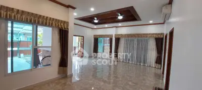 Spacious living room with elegant ceiling fans and large windows for natural light.