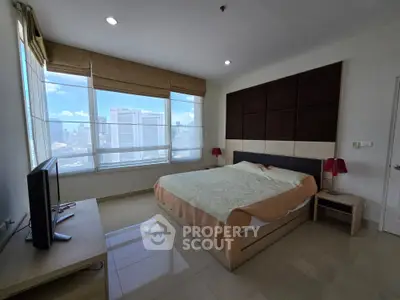 Spacious bedroom with city view, modern furnishings, and ample natural light.