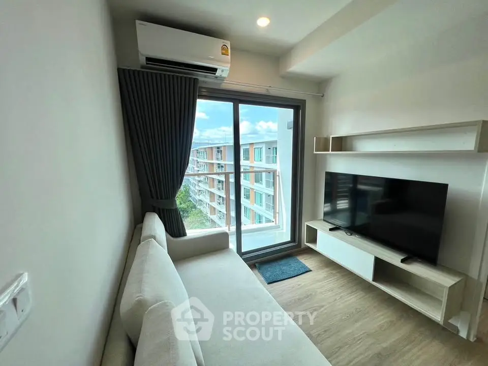Modern living room with large window and balcony view in a stylish apartment.