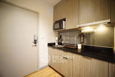 Modern kitchen with sleek cabinetry and built-in appliances in a cozy apartment.