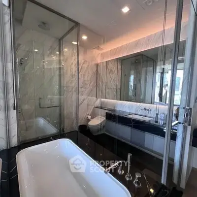 Luxurious modern bathroom with elegant marble finishes and spacious bathtub.