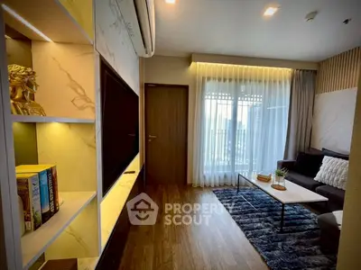 Modern living room with stylish decor and natural light, featuring a cozy seating area and elegant shelving.