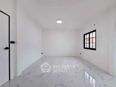 Spacious empty room with modern marble flooring and large window.