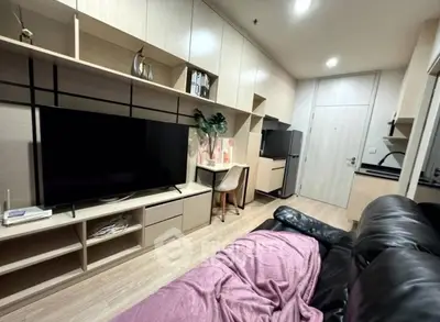 Modern living room with sleek built-in storage and large TV, perfect for cozy relaxation.