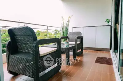 Spacious balcony with modern outdoor furniture and lush green view.