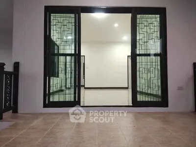 Spacious interior with elegant sliding doors and tiled flooring, perfect for modern living.