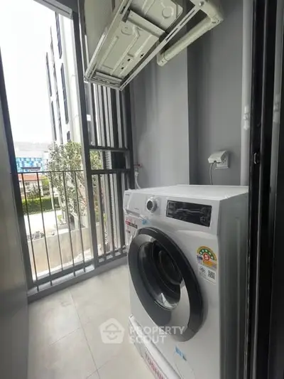 Modern apartment balcony with washing machine and air conditioning unit, offering functional outdoor space.