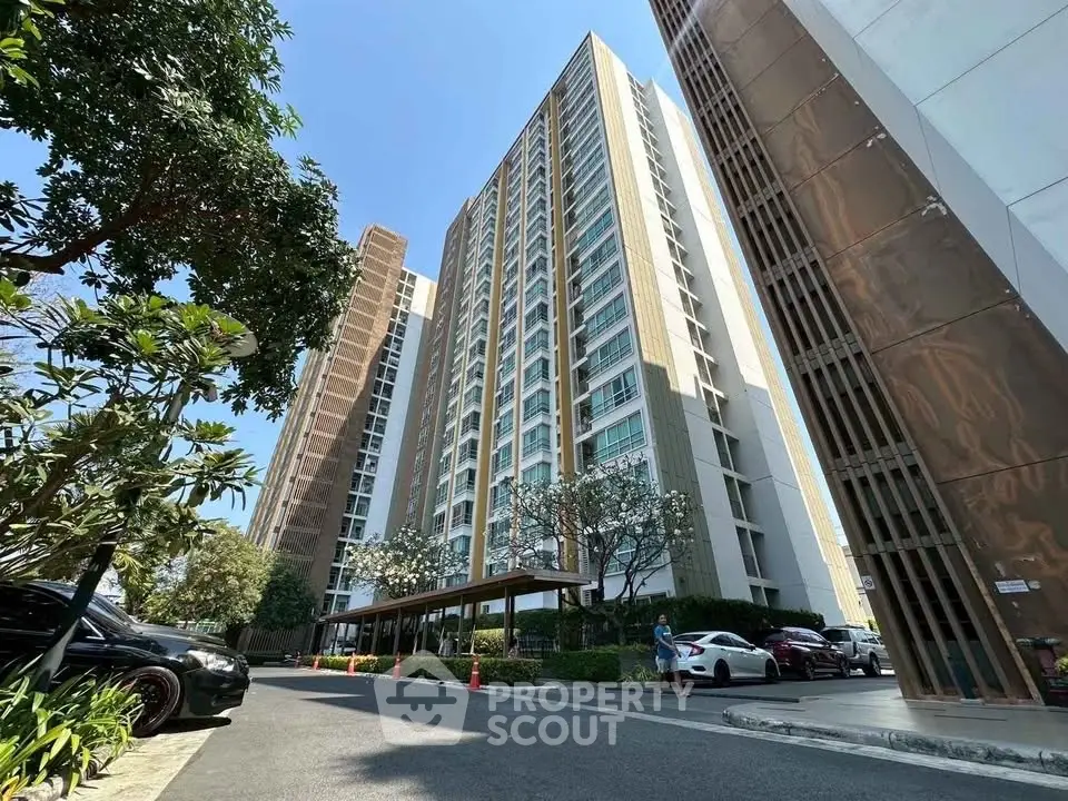 Modern high-rise condominium with lush landscaping and ample parking space.