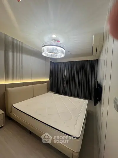 Luxurious bedroom with elegant lighting and modern decor, featuring a large bed and stylish curtains.