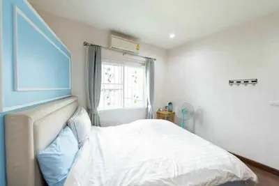 Cozy bedroom with modern decor and natural light, featuring a comfortable bed and stylish curtains.