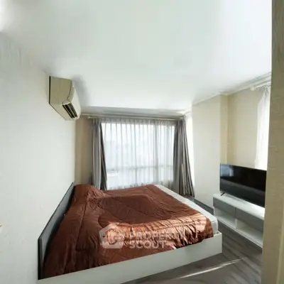 Spacious bedroom with large windows and modern furnishings in a stylish apartment.