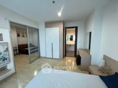 Spacious modern bedroom with ensuite bathroom and sliding glass doors to living area.