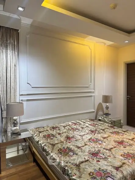 Luxurious bedroom with elegant decor and floral bedding in modern apartment.