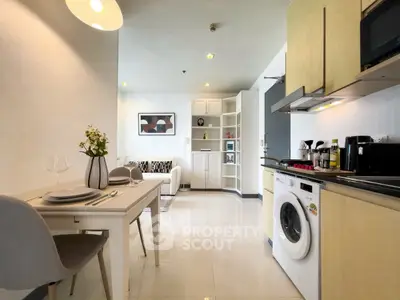 Modern open-plan kitchen and living area with washing machine and stylish decor.