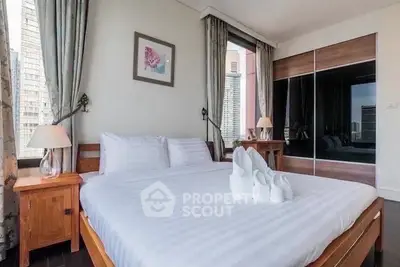 Luxurious bedroom with modern decor and city view, featuring elegant furnishings and ample natural light.