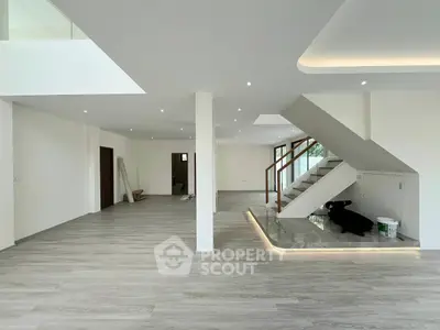 Spacious modern living room with sleek staircase and elegant lighting